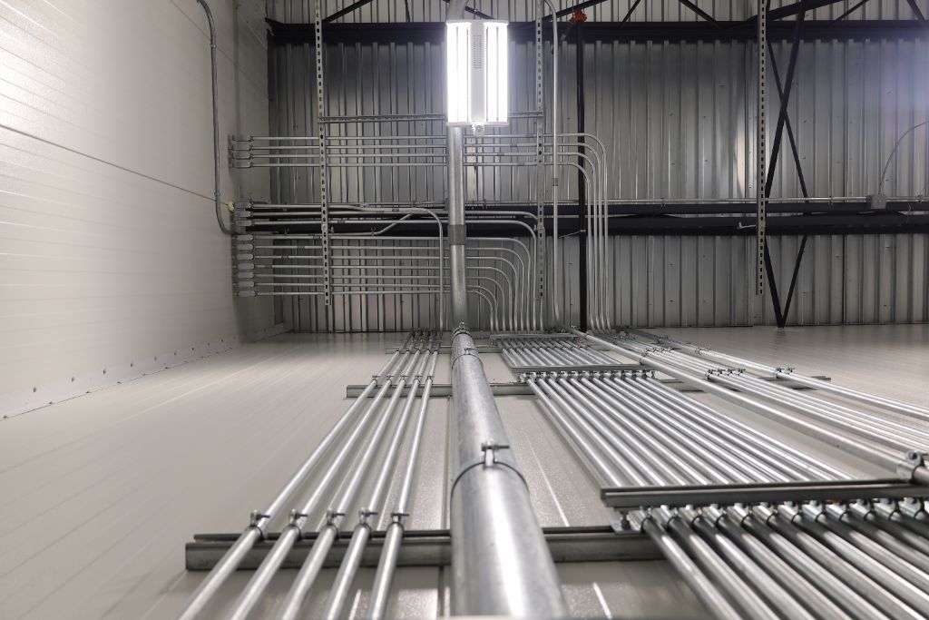 Industrial refrigeration piping and electrical conduit infrastructure inside Mid Eastern Cold Storage